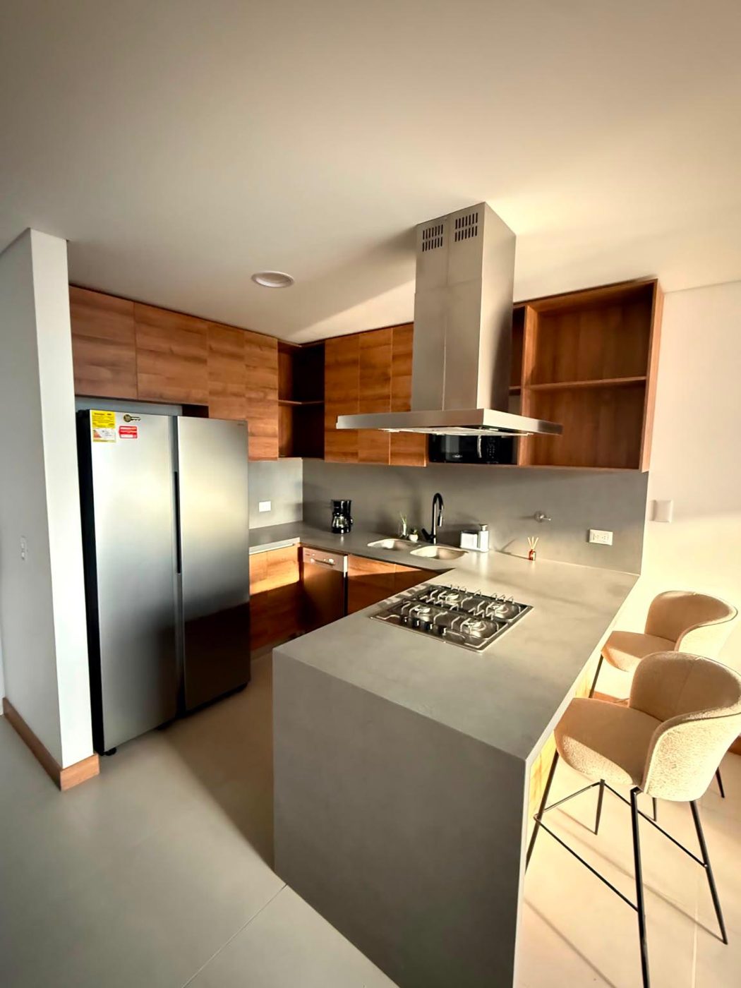 Cocina equipada con barra y heladera doble puerta
